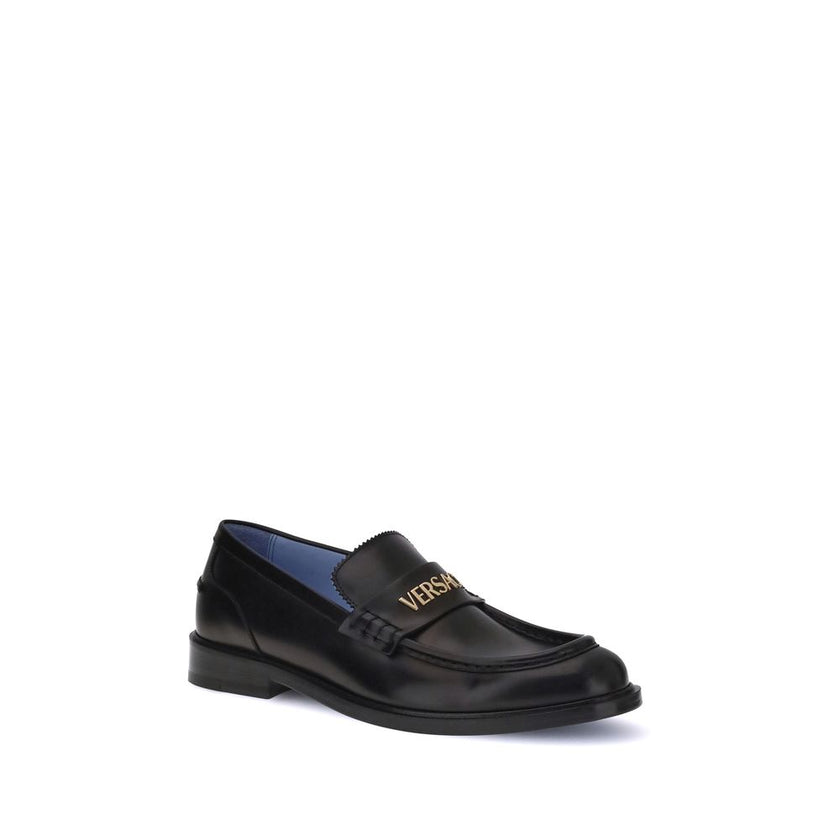 Black Calf Leather Bos Taurus Slip-On LoafersVersace’s Leather Loafers combine elegance and practicality in a slip-on design. Featuring a rounded toe, they feature the gold logo applied to the front tray, giving a distinctive and refined touch to this cla