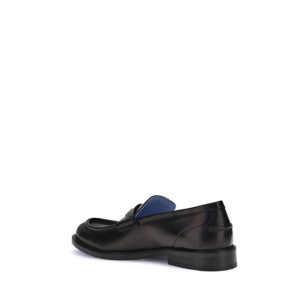 Black Calf Leather Bos Taurus Slip-On LoafersVersace’s Leather Loafers combine elegance and practicality in a slip-on design. Featuring a rounded toe, they feature the gold logo applied to the front tray, giving a distinctive and refined touch to this cla