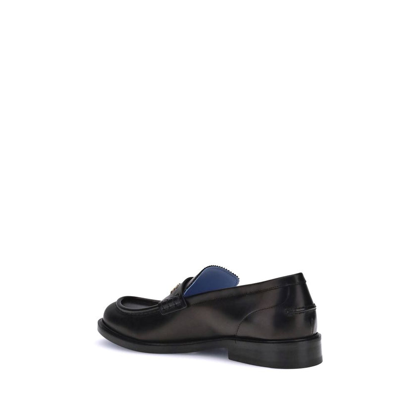 Black Calf Leather Bos Taurus Slip-On LoafersVersace’s Leather Loafers combine elegance and practicality in a slip-on design. Featuring a rounded toe, they feature the gold logo applied to the front tray, giving a distinctive and refined touch to this cla