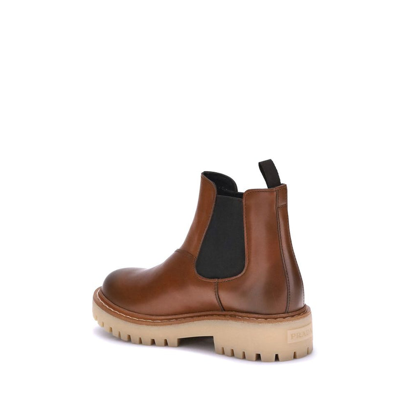 Brown Rubber Chelsea BootsPrada’s Chelsea Ankle Boots reinterpret a timeless classic with a contemporary and functional aesthetic. Made with elastic side inserts, they offer a comfortable and quick fit.The lightened rubber sole and shell construction ensu