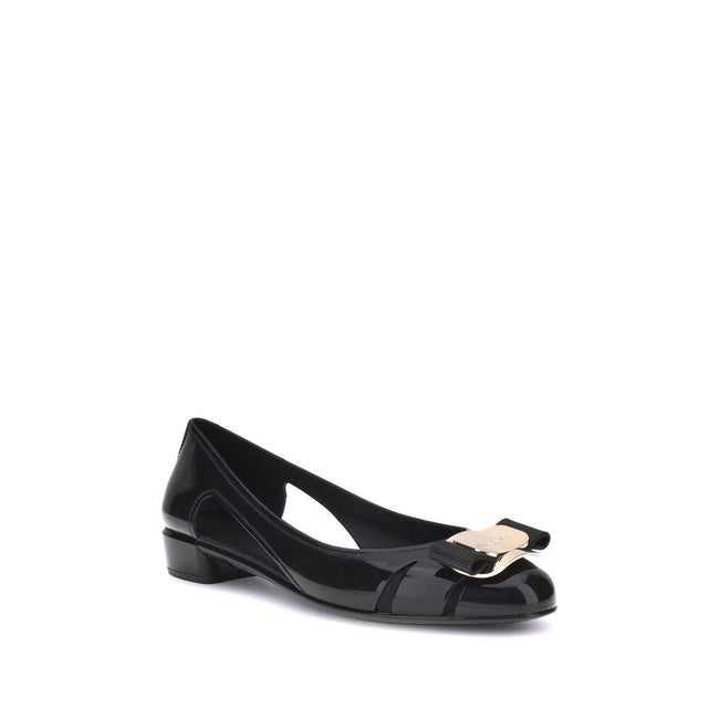 Black Rubber Ballet FlatsFerragamo’s Rubber Ballerina combines elegance and practicality with a sleek, modern design. The low block heel ensures comfort, while the side cut-out details lend lightness to the silhouette. The metallic logo bow on the front a