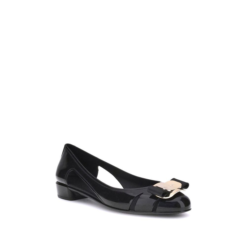 Black Rubber Ballet FlatsFerragamo’s Rubber Ballerina combines elegance and practicality with a sleek, modern design. The low block heel ensures comfort, while the side cut-out details lend lightness to the silhouette. The metallic logo bow on the front a