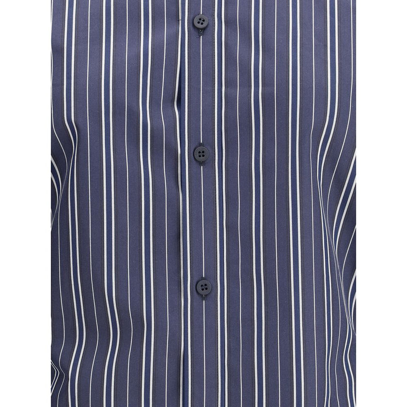 Blue Cotton Pattern ShirtThe Balenciaga Striped Shirt reinterprets a wardrobe classic with the brand’s bold aesthetic. Featuring a classic collar and a front button closure, it has an oversized design and two side vents that add movement and modernity. A