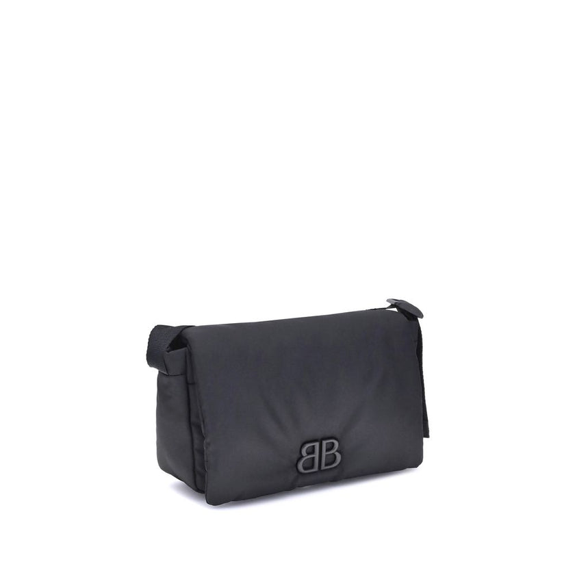 Black Polyamide Shoulder BagBalenciaga’s Monaco Shoulder Bag, made of lightweight and durable nylon, stands out for its minimalist and functional design. The top flap with magnetic closure ensures practicality, while the adjustable shoulder strap allows f