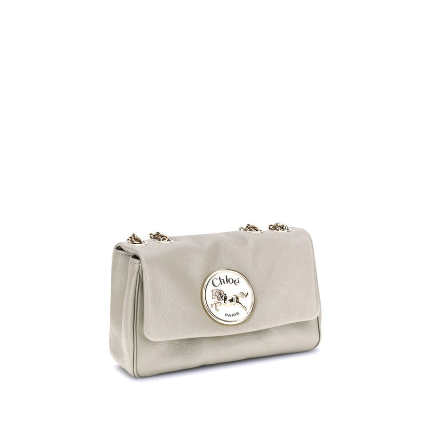 Beige Calf Leather Bos Taurus Shoulder BagChloé’s Heritage Shoulder Bag is a refined and versatile accessory made of soft grained leather. Its aesthetic is embellished with a metallic logo detail on the front, underscoring its design identity. The metal c