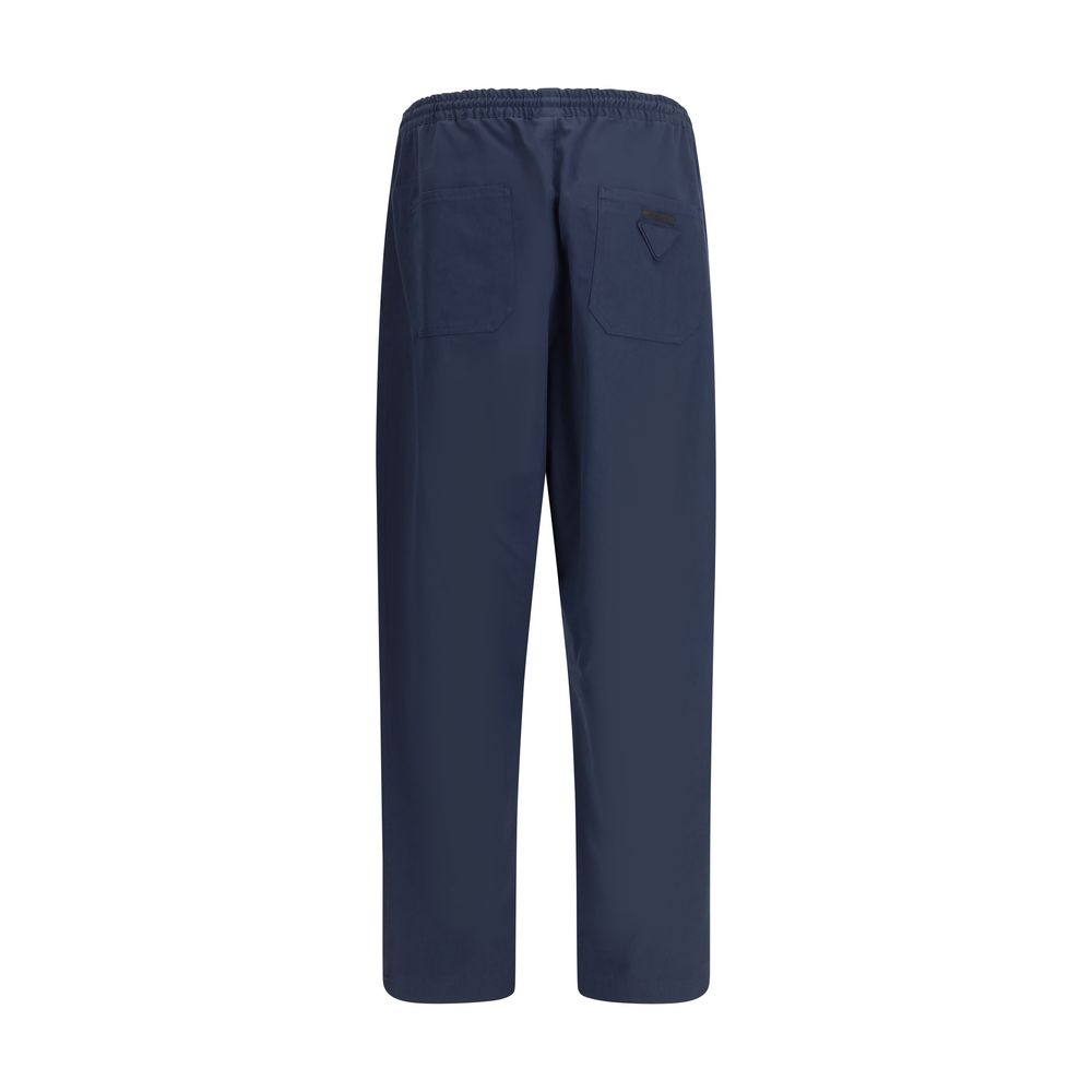 Blue Cotton Casual PantsPrada’s Cotton Pants combine comfort and style with an elasticized drawstring waistband and front zipper closure. They feature two side welt pockets and two patch pockets on the back, embellished with the iconic logo that adds a di