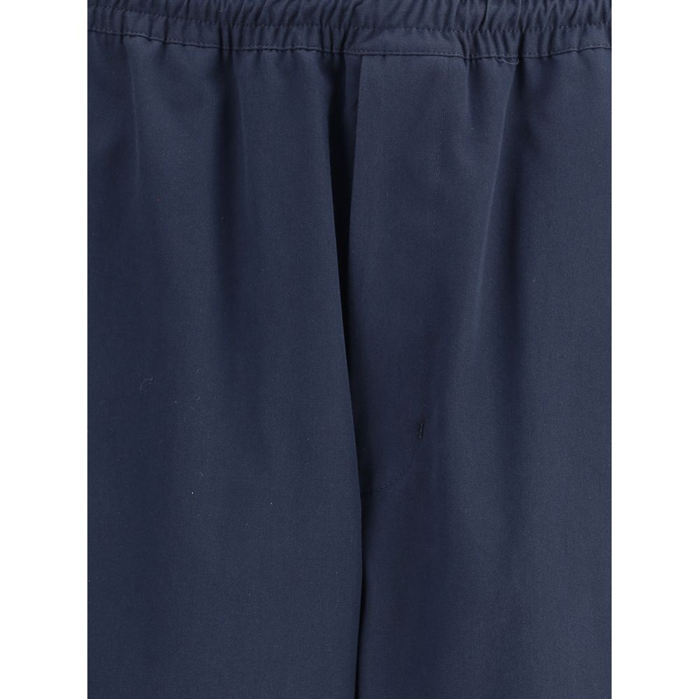 Blue Cotton Casual PantsPrada’s Cotton Pants combine comfort and style with an elasticized drawstring waistband and front zipper closure. They feature two side welt pockets and two patch pockets on the back, embellished with the iconic logo that adds a di