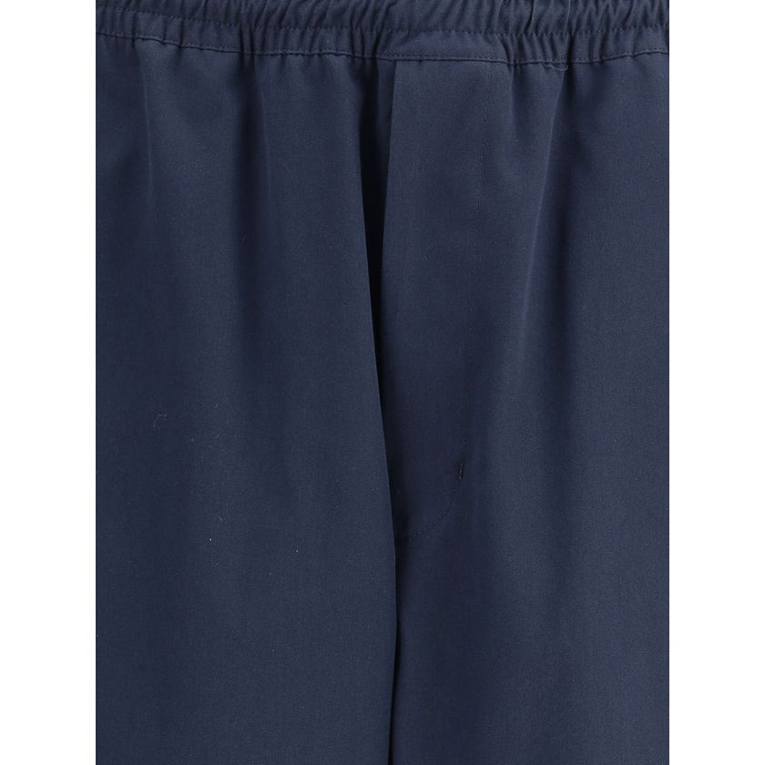 Blue Cotton Casual PantsPrada’s Cotton Pants combine comfort and style with an elasticized drawstring waistband and front zipper closure. They feature two side welt pockets and two patch pockets on the back, embellished with the iconic logo that adds a di