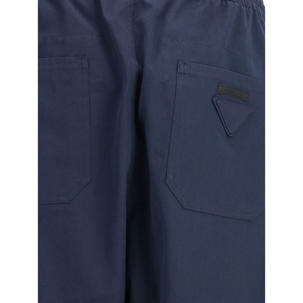 Blue Cotton Casual PantsPrada’s Cotton Pants combine comfort and style with an elasticized drawstring waistband and front zipper closure. They feature two side welt pockets and two patch pockets on the back, embellished with the iconic logo that adds a di