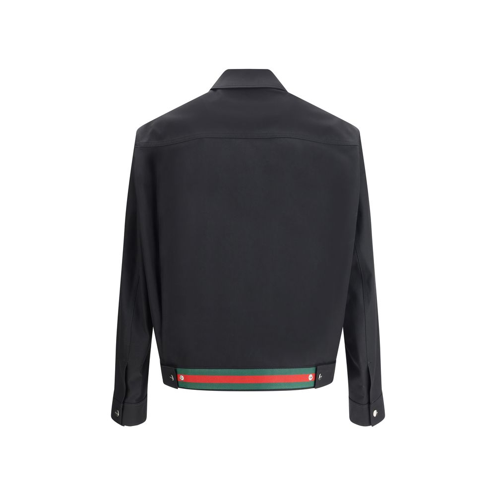 Black Cotton Shell JacketCotton Jacket by Gucci with classic collar and front zip closure. The model features two side welt pockets and adjustable cuffs with a button. The iconic multicolored stripes, a distinctive symbol of the Maison, stand out on the b