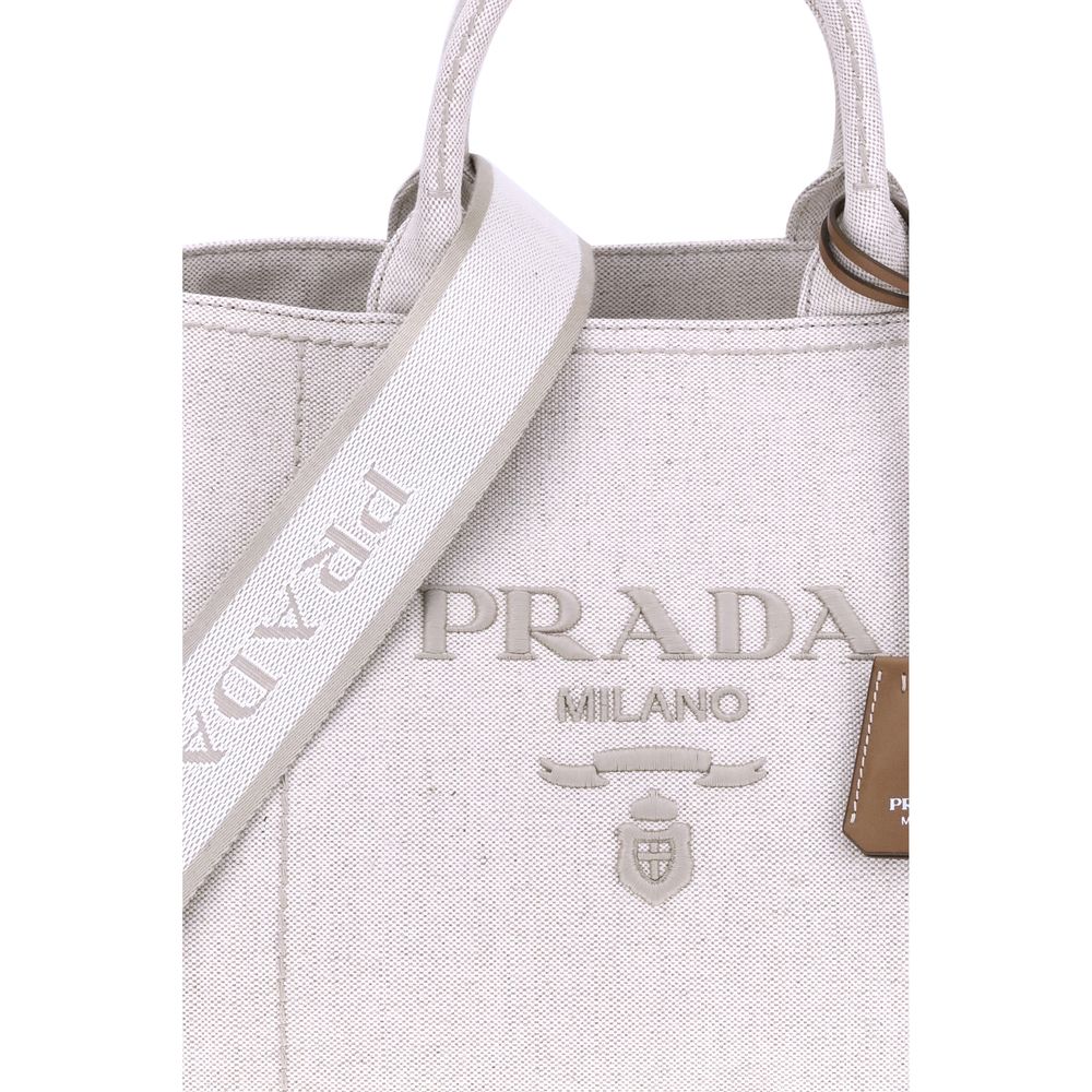 Cream Cotton Shoulder BagPrada’s extra large Jardinière Handbag combines elegance and functionality in a high-quality linen blend. Featuring two tubular handles and exposed topstitching, it has an adjustable and removable ribbon shoulder strap for differe