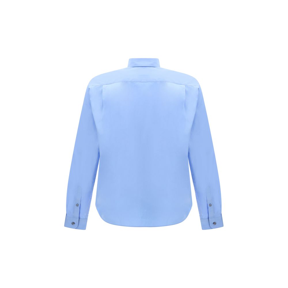 Light Blue Cotton Dress ShirtThe Prada Cotton Shirt is an essential piece with a refined style. Featuring a classic collar and front button closure, it stands out for the iconic signature sewn on the front, a discreet but unmistakable detail. Season: AW25
