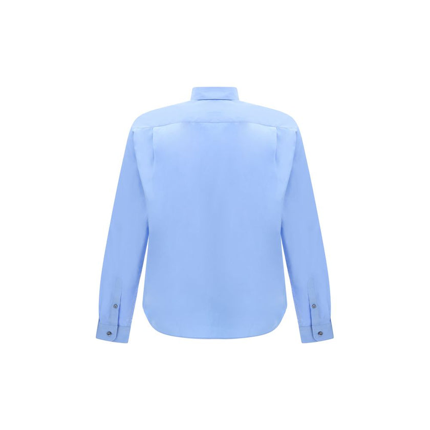 Light Blue Cotton Dress ShirtThe Prada Cotton Shirt is an essential piece with a refined style. Featuring a classic collar and front button closure, it stands out for the iconic signature sewn on the front, a discreet but unmistakable detail. Season: AW25