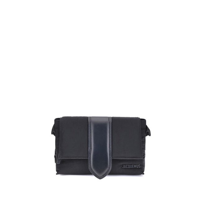 Black Nylon HandbagThe Jacquemus Nylon Bambino Shoulder Bag reinterprets the messenger style with a contemporary and functional twist. Crafted from soft nylon, it features a leather handle and a magnetic flap with a leather tab, which hides a zip closure
