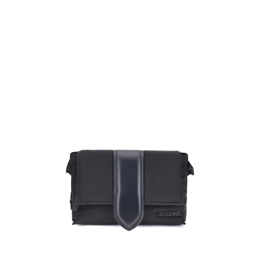 Black Nylon HandbagThe Jacquemus Nylon Bambino Shoulder Bag reinterprets the messenger style with a contemporary and functional twist. Crafted from soft nylon, it features a leather handle and a magnetic flap with a leather tab, which hides a zip closure