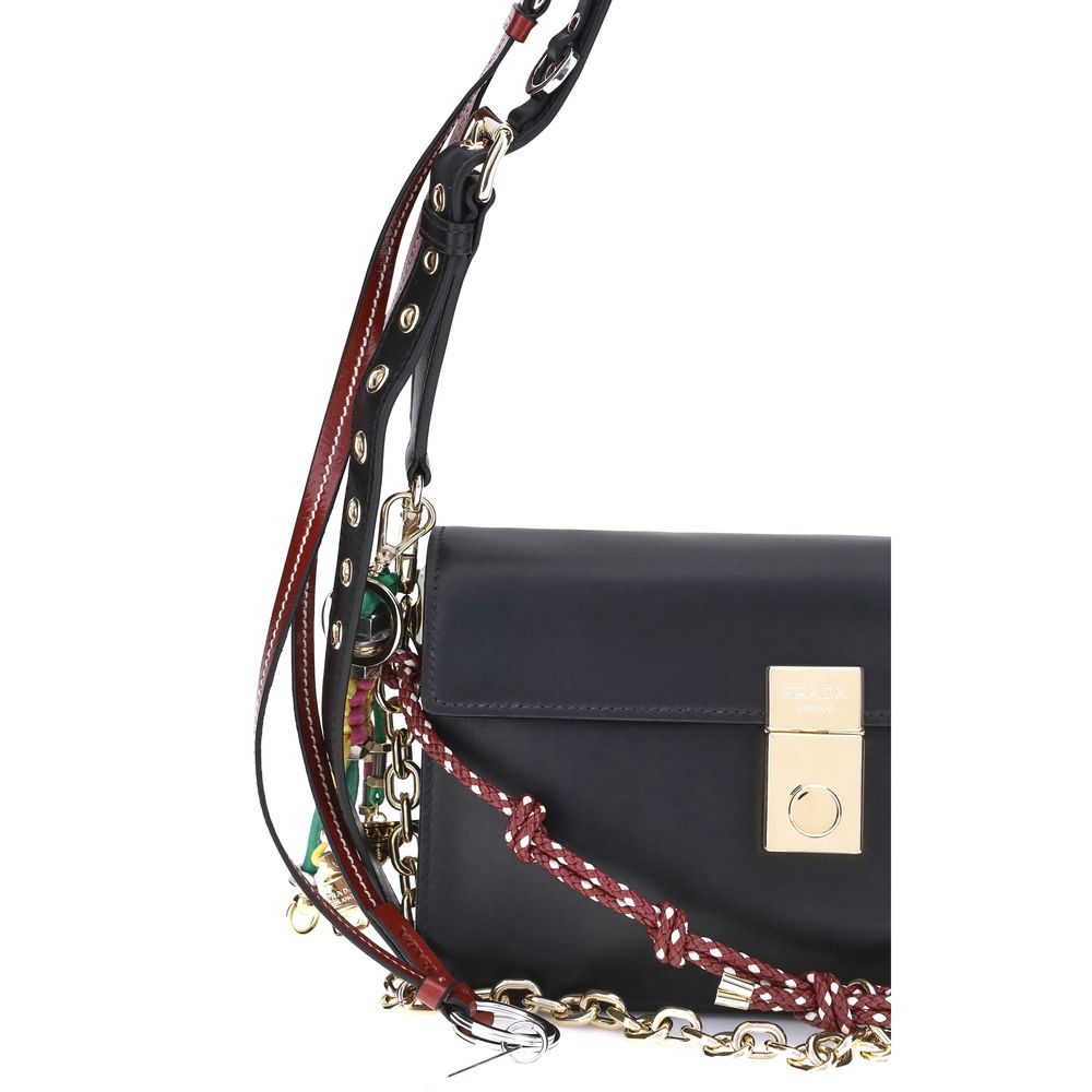 Black Calf Leather Bos Taurus Shoulder BagPrada’s Soft Sound Small Shoulder Bag combines soft lines and refined details in a compact and functional design. Made of lightly grained leather, it is embellished with a metallic logo detail on the front and rem