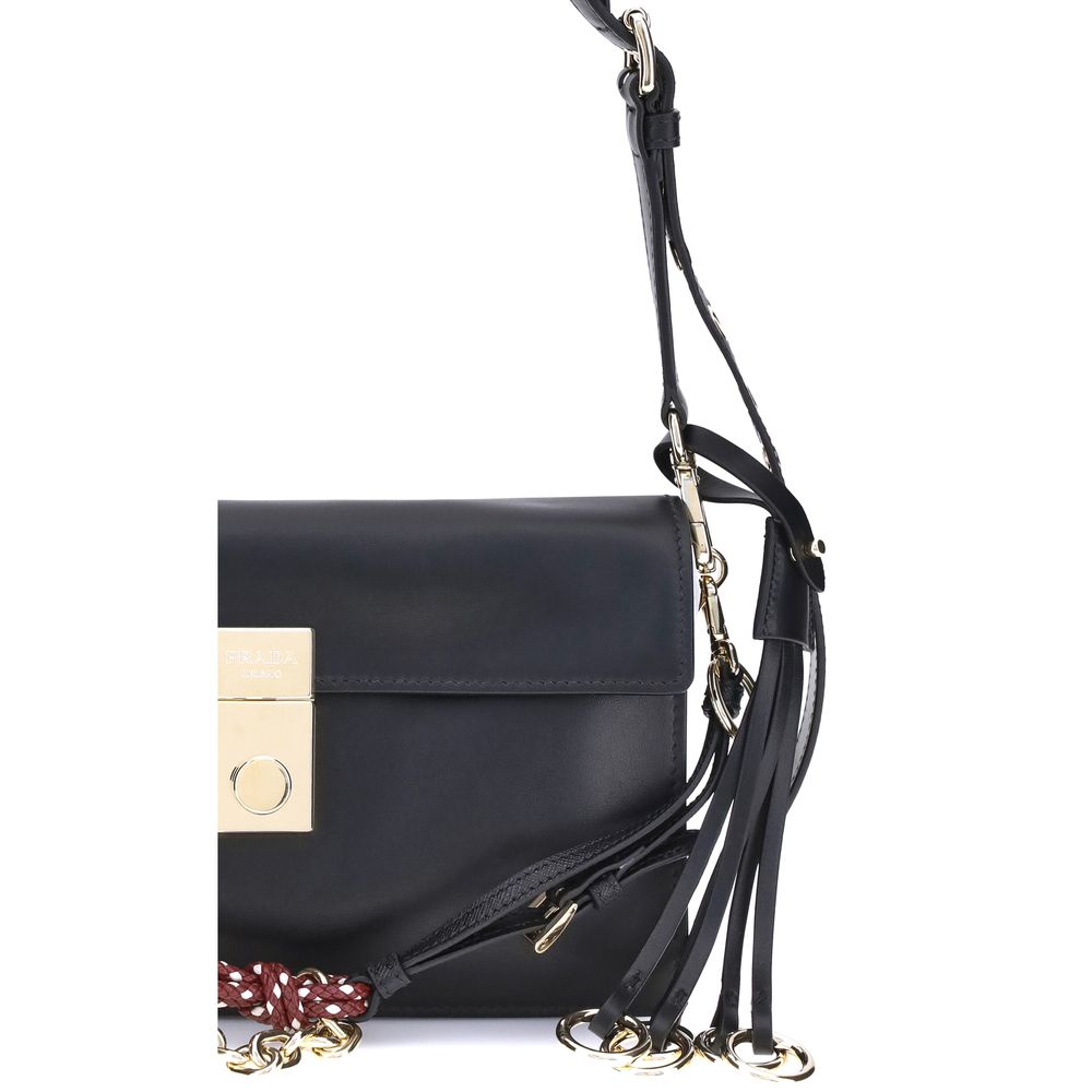 Black Calf Leather Bos Taurus Shoulder BagPrada’s Soft Sound Small Shoulder Bag combines soft lines and refined details in a compact and functional design. Made of lightly grained leather, it is embellished with a metallic logo detail on the front and rem