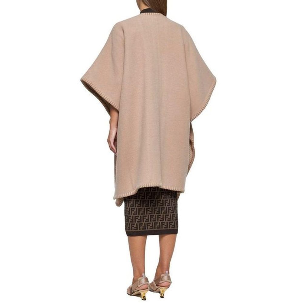 Beige Cashmere PonchoDescription: – Composition: 10% Cashmere 90% Wool – Dry clean – Side logo lettering – Three-quarter sleeves – No closure – Rounded edges – Contrasting topstitching – Made in Italy – Gender: WOMEN – Size & Fit: Deconstructed model with