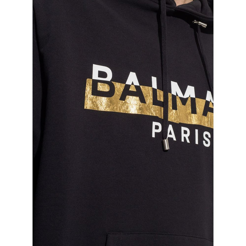 Black Cotton SweatshirtDescription: – Composition: 100% Cotton – Ribbed trims – Machine wash – Drawstring hood – Kangaroo pocket – Front logo detail – Gold-tone graphic print – Made in Italy – Gender: MEN – Size & Fit: True to size. Regular fit. Model’s M
