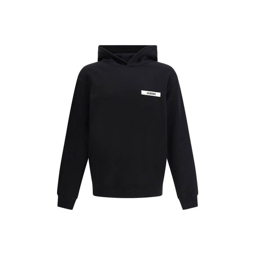 Black Cotton SweatshirtJacquemus’ Hooded Sweatshirt, made of soft cotton with a plush interior, offers snug comfort that is ideal for everyday wear. The clean design is embellished with an applied logo patch on the front, adding a distinctive and recogniz