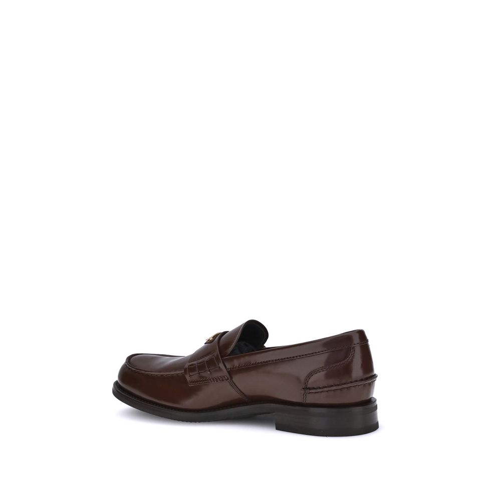 Brown Calf Leather Bos Taurus Slip-On LoafersPrada’s leather Loafers are a mix of classic elegance and distinctive details. The slightly elongated round toe and leather block heel ensure comfort and style. The iconic enameled triangular plaque with the br