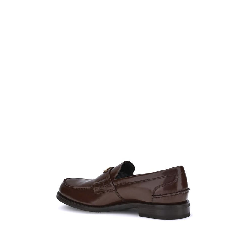 Brown Calf Leather Bos Taurus Slip-On LoafersPrada’s leather Loafers are a mix of classic elegance and distinctive details. The slightly elongated round toe and leather block heel ensure comfort and style. The iconic enameled triangular plaque with the br