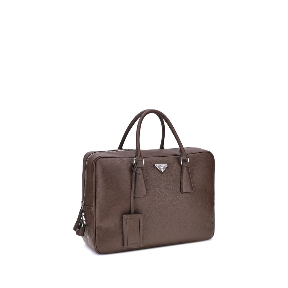 Brown Calf Leather Bos Taurus BriefcasePrada’s Men’s Handbag is an elegant and functional accessory designed to accompany everyday life in style. Equipped with two round handles and a top zipper closure, it features the iconic triangular plaque applied on