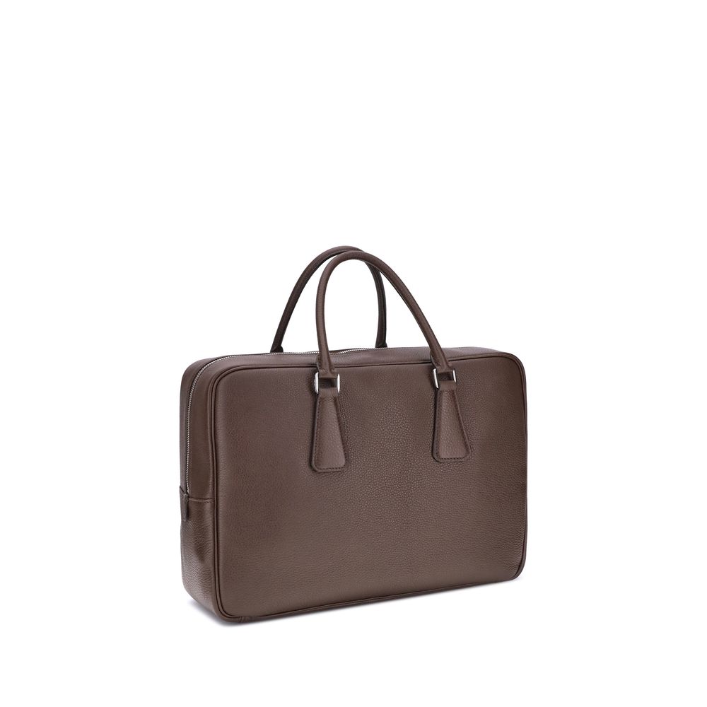 Brown Calf Leather Bos Taurus BriefcasePrada’s Men’s Handbag is an elegant and functional accessory designed to accompany everyday life in style. Equipped with two round handles and a top zipper closure, it features the iconic triangular plaque applied on