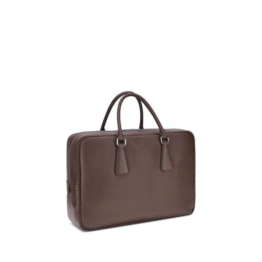 Brown Calf Leather Bos Taurus BriefcasePrada’s Men’s Handbag is an elegant and functional accessory designed to accompany everyday life in style. Equipped with two round handles and a top zipper closure, it features the iconic triangular plaque applied on