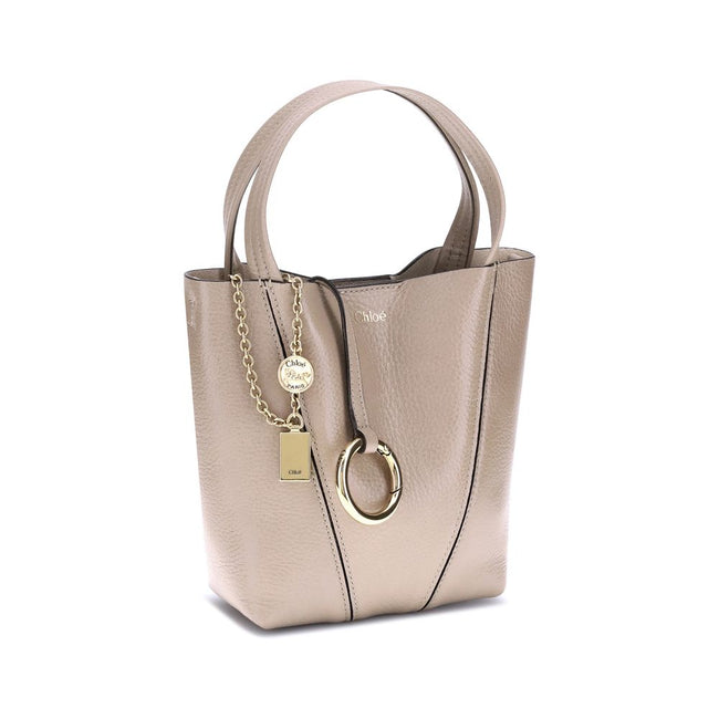 Beige Calf Leather Bos Taurus Shoulder BagThe Spin Shoulder Bag by Chloé, crafted by shiny grained leather, features an elegant design with two flat top handles and an adjustable shoulder strap. The closure is secured by a magnetic button, while the detai