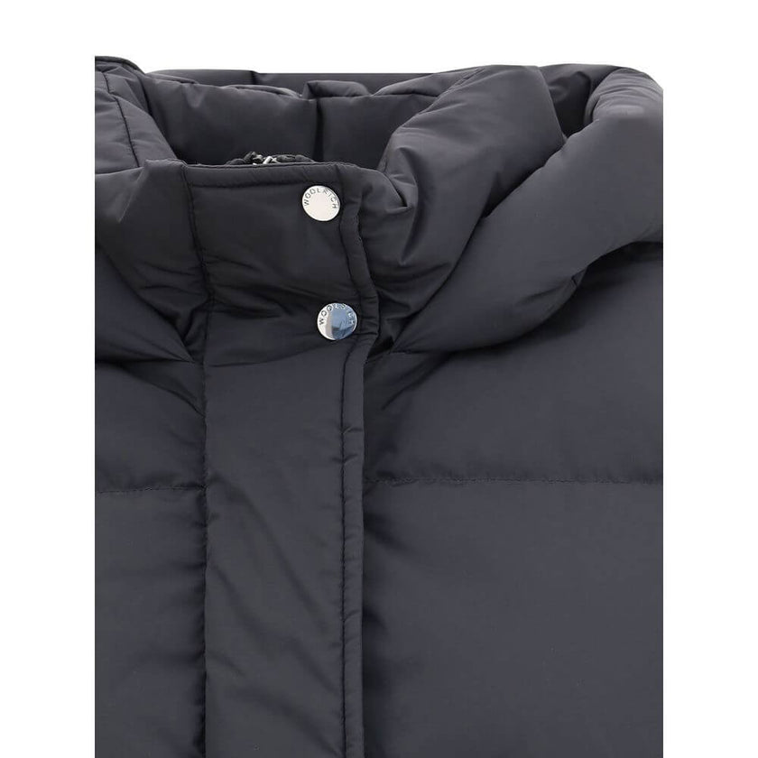 Black Goose Down CoatThe Kelly Down Jacket by Woolrich combines practicality and contemporary style. Featuring elastic cuffs and a hood, it features a front zipper and button closure, zippered side slits and two welt pockets. The padded and quilted design