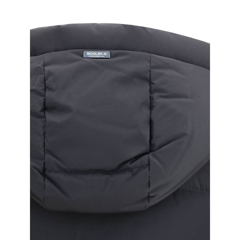 Black Goose Down CoatThe Kelly Down Jacket by Woolrich combines practicality and contemporary style. Featuring elastic cuffs and a hood, it features a front zipper and button closure, zippered side slits and two welt pockets. The padded and quilted design