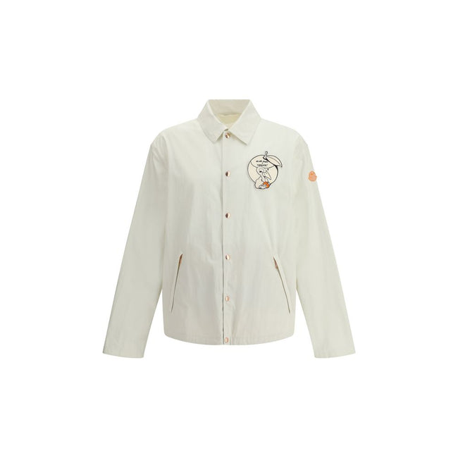 White Cotton CoatThe Moncler x Gilga Farm Satsuma Shirt Jacket by Donald Glover fuses workwear style and visual storytelling. Crafted from durable cotton and nylon canvas, it is part of the Moncler Genius line and stands out for its comic-style patches an