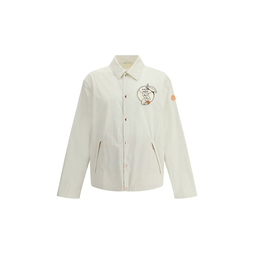 White Cotton CoatThe Moncler x Gilga Farm Satsuma Shirt Jacket by Donald Glover fuses workwear style and visual storytelling. Crafted from durable cotton and nylon canvas, it is part of the Moncler Genius line and stands out for its comic-style patches an