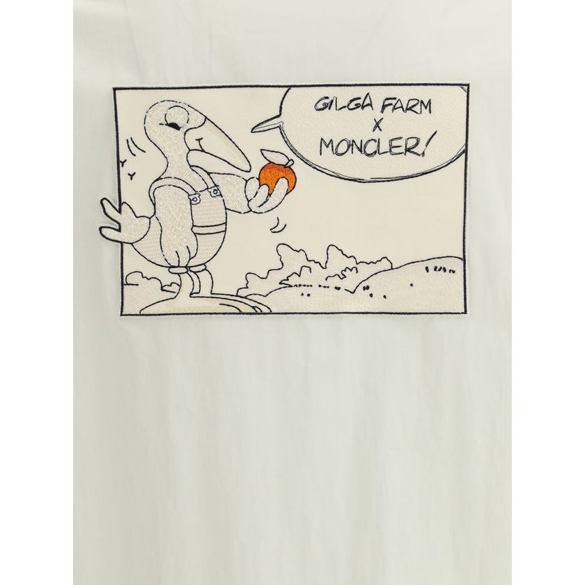 White Cotton CoatThe Moncler x Gilga Farm Satsuma Shirt Jacket by Donald Glover fuses workwear style and visual storytelling. Crafted from durable cotton and nylon canvas, it is part of the Moncler Genius line and stands out for its comic-style patches an