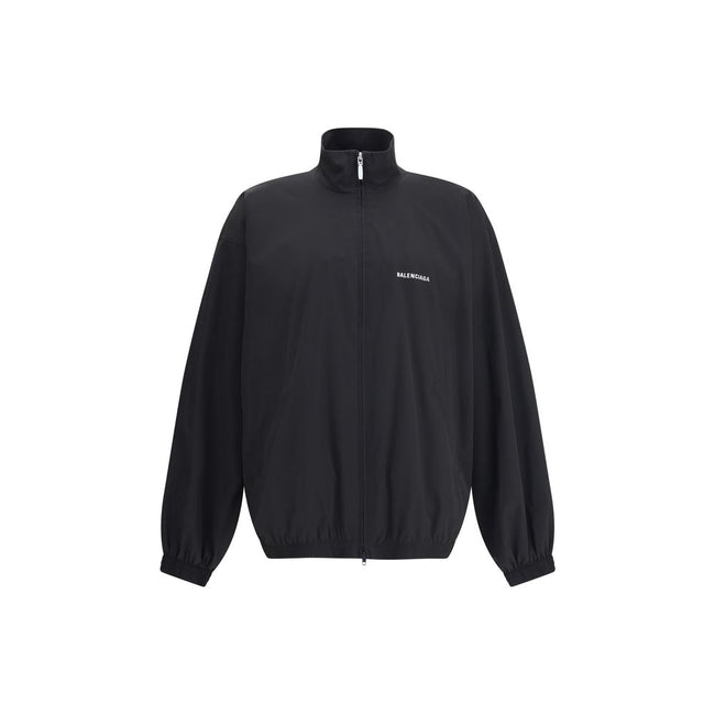 Black Polyester Shell JacketBalenciaga’s Oversized Windbreaker Jacket is a garment with a bold, sporty aesthetic made from durable technical fabric. Featuring contrasting Balenciaga embroidery on the chest and back, it has a high collar, concealed front z