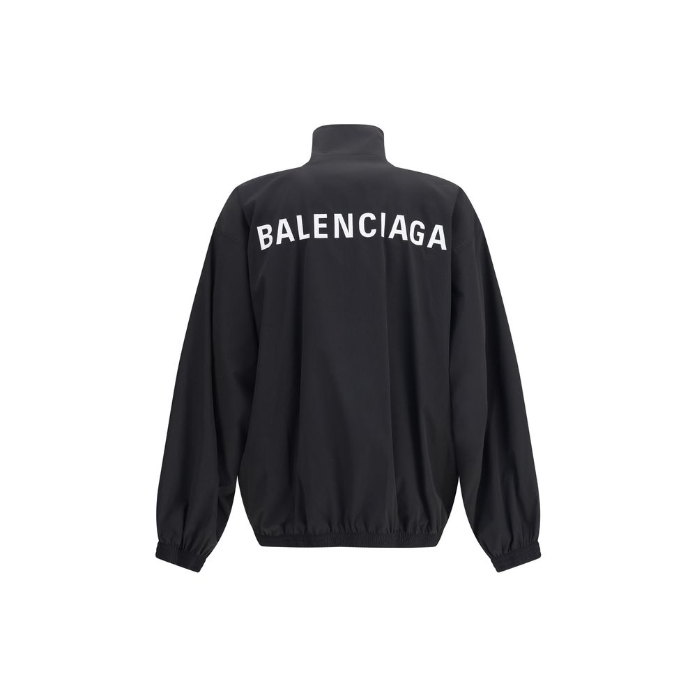 Black Polyester Shell JacketBalenciaga’s Oversized Windbreaker Jacket is a garment with a bold, sporty aesthetic made from durable technical fabric. Featuring contrasting Balenciaga embroidery on the chest and back, it has a high collar, concealed front z