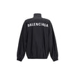 Black Polyester Shell JacketBalenciaga’s Oversized Windbreaker Jacket is a garment with a bold, sporty aesthetic made from durable technical fabric. Featuring contrasting Balenciaga embroidery on the chest and back, it has a high collar, concealed front z