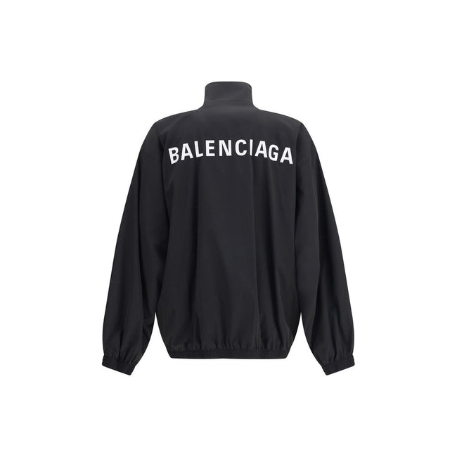 Black Polyester Shell JacketBalenciaga’s Oversized Windbreaker Jacket is a garment with a bold, sporty aesthetic made from durable technical fabric. Featuring contrasting Balenciaga embroidery on the chest and back, it has a high collar, concealed front z
