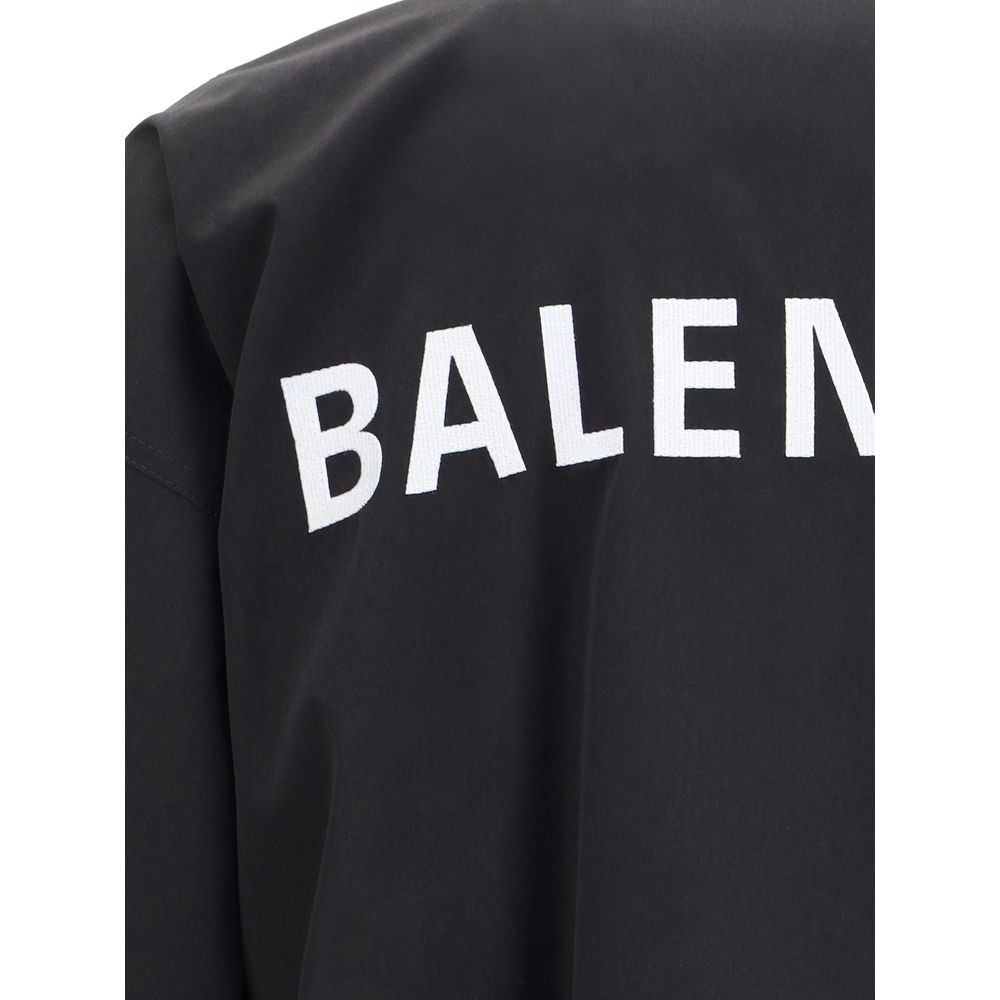Black Polyester Shell JacketBalenciaga’s Oversized Windbreaker Jacket is a garment with a bold, sporty aesthetic made from durable technical fabric. Featuring contrasting Balenciaga embroidery on the chest and back, it has a high collar, concealed front z