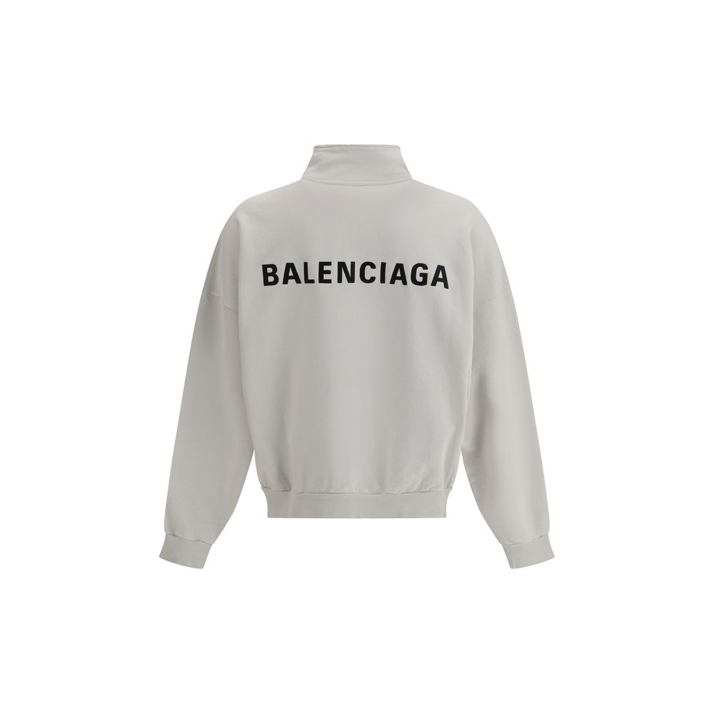 White Cotton SweatshirtBalenciaga’s Logo Sweatshirt stands out for its worn effect, which gives the garment a worn and contemporary character. On the front it features two patch pockets, practical and with a casual look, while the hem and cuffs are finish