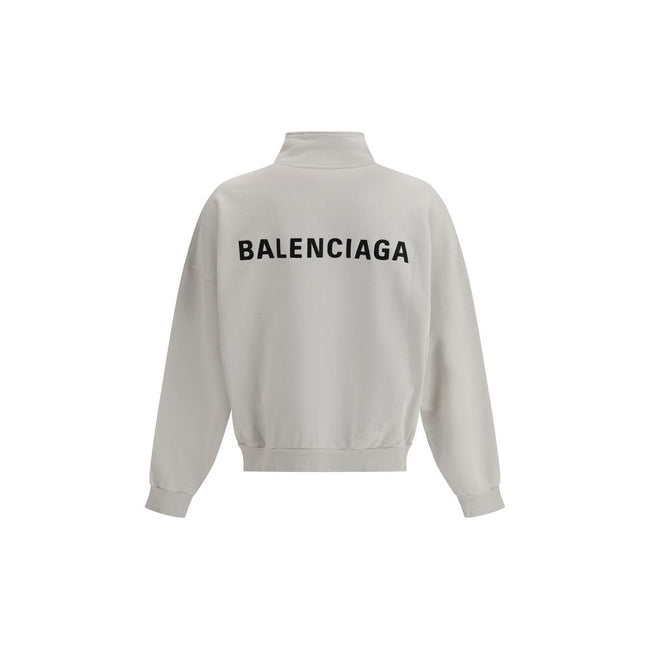 White Cotton SweatshirtBalenciaga’s Logo Sweatshirt stands out for its worn effect, which gives the garment a worn and contemporary character. On the front it features two patch pockets, practical and with a casual look, while the hem and cuffs are finish