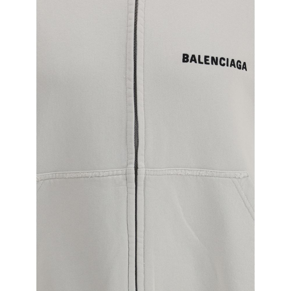 White Cotton SweatshirtBalenciaga’s Logo Sweatshirt stands out for its worn effect, which gives the garment a worn and contemporary character. On the front it features two patch pockets, practical and with a casual look, while the hem and cuffs are finish