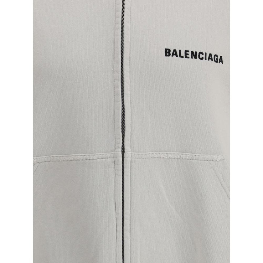 White Cotton SweatshirtBalenciaga’s Logo Sweatshirt stands out for its worn effect, which gives the garment a worn and contemporary character. On the front it features two patch pockets, practical and with a casual look, while the hem and cuffs are finish
