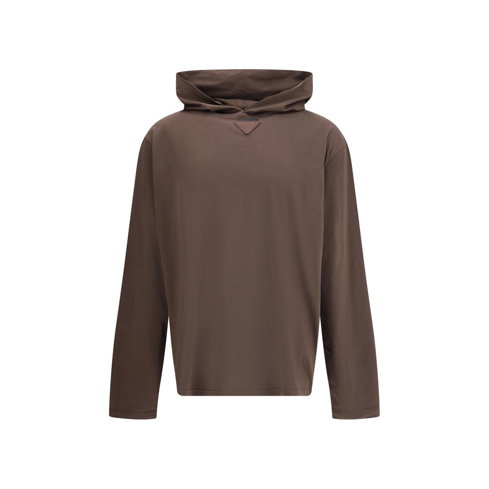 Brown Cotton SweatshirtPrada’s lightweight Hoodie is a garment with a modern, minimalist allure. The triangular logo patch on the front adds an iconic and recognizable detail, while the lightweight fabric ensures comfort and versatility, ideal for a casua