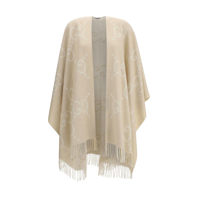 Beige Cashmere CoatCashmere Cape by Gucci, reversible cape design, shawl lapels, frayed hem, iconic all-over contrasting brand logo, oversized fit. Season: AW25 Fit: Regular Composition: 100% Kashmir/capra Hircus MADE IN ITALYBeige Cashmere Coat${tagsGucc