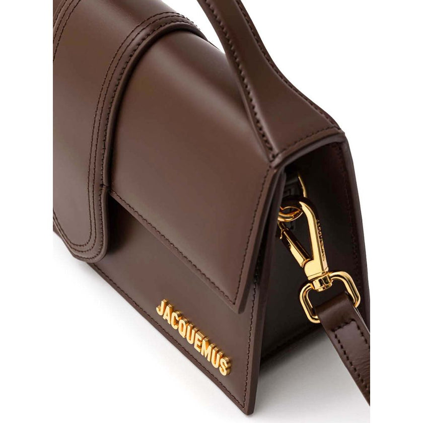 Brown Leather HandbagLe Grand Bambino Brown Leather Bag Jacquemus. Front opening with rigid flap and covered snap button. Single internal pocket, removable shoulder strap, applied back pocket. Composition: 100% Leather Brand Sku: 213BA007- 3100 850Brown L