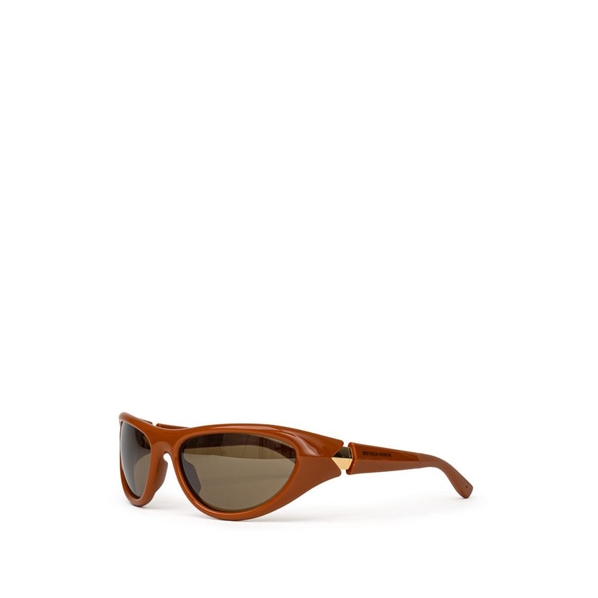 Brown Acetate SunglassesBottega Veneta Brown Acetate Sunglasses. Elongated sporty frame in brown leather, slightly mirrored dark lenses, gold details on the temples, logo embossed on the arm. Composition: Acetate Internal SKU: 25GIU84 Brand SKU: 744692VBL