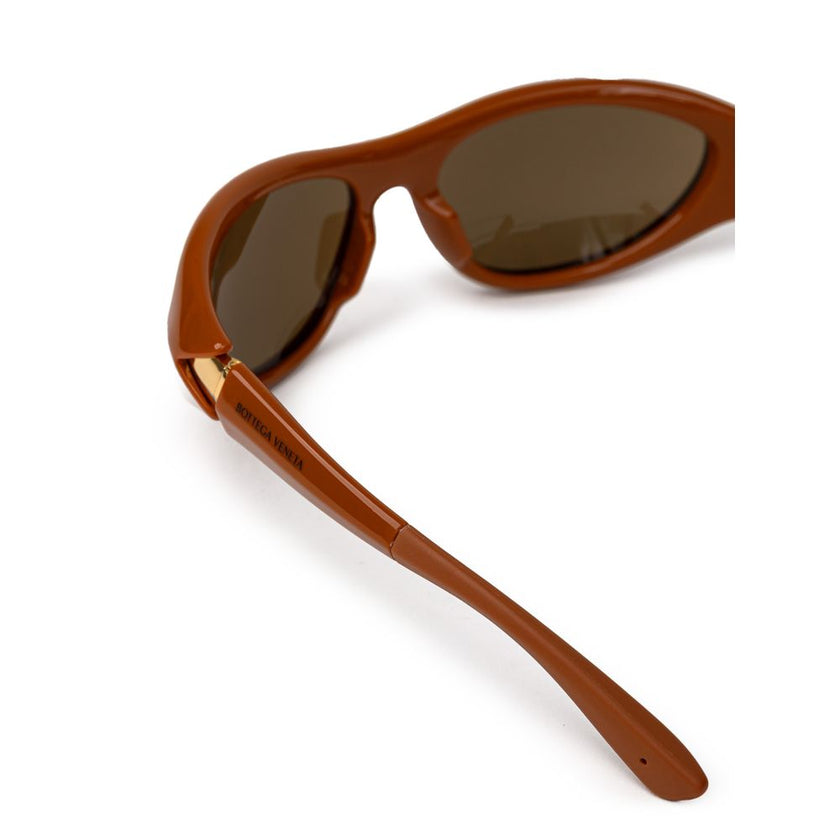 Brown Acetate SunglassesBottega Veneta Brown Acetate Sunglasses. Elongated sporty frame in brown leather, slightly mirrored dark lenses, gold details on the temples, logo embossed on the arm. Composition: Acetate Internal SKU: 25GIU84 Brand SKU: 744692VBL