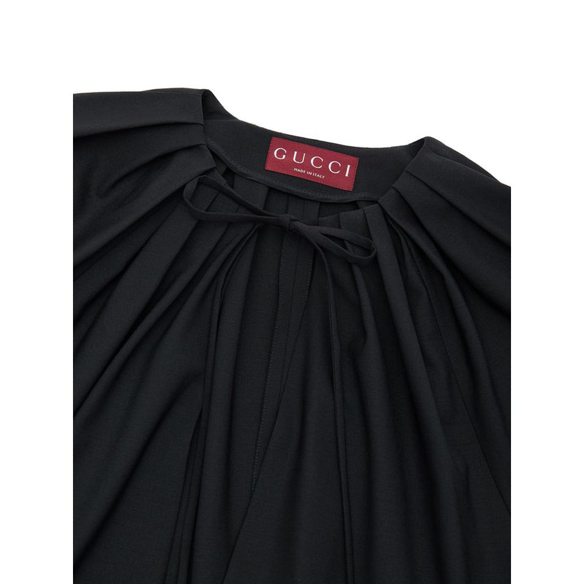 Black Wool JumpsuitBlack Tracksuit Dress with Gucci Belt. Crewneck, wide neckline adjustable with lace, long sleeves closed with button. Removable thin patent leather belt with GG logo at the waist. Wide leg. Composition: 96% Wool, 4% Elastane Internal SK